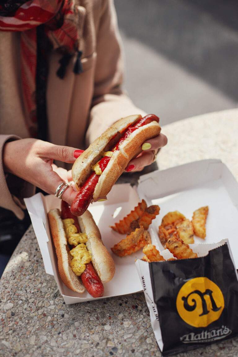 Une fille tient un hot dog dans une main
