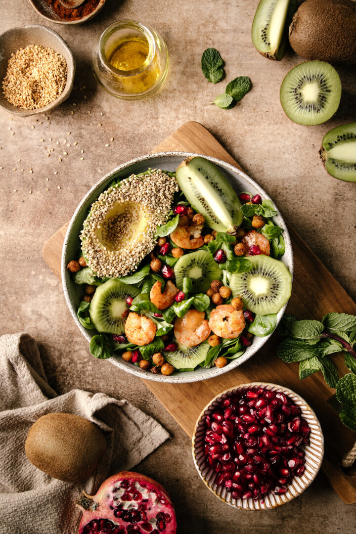 salade hivernale avec des crevettes et des kiwis vue du dessus posée sur une table