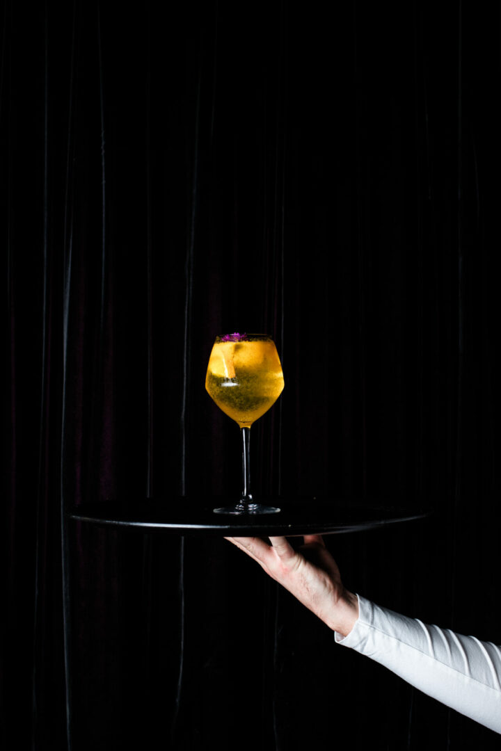 un serveur tient un plateau avec un cocktail